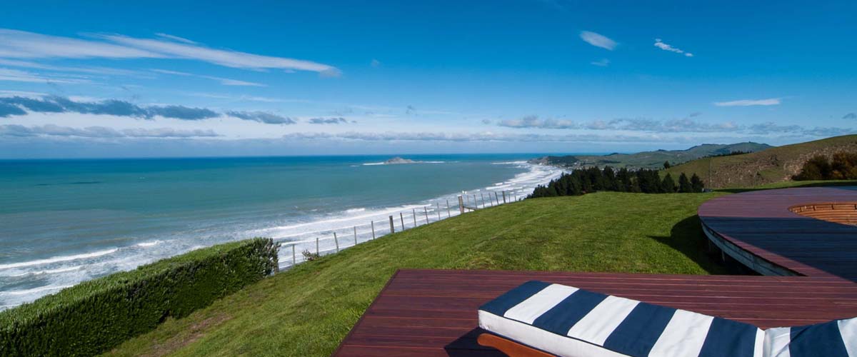 Sunlounger with comfortable cushions on the deck with a view over the Pacific ocean this is luxury escape in NZ